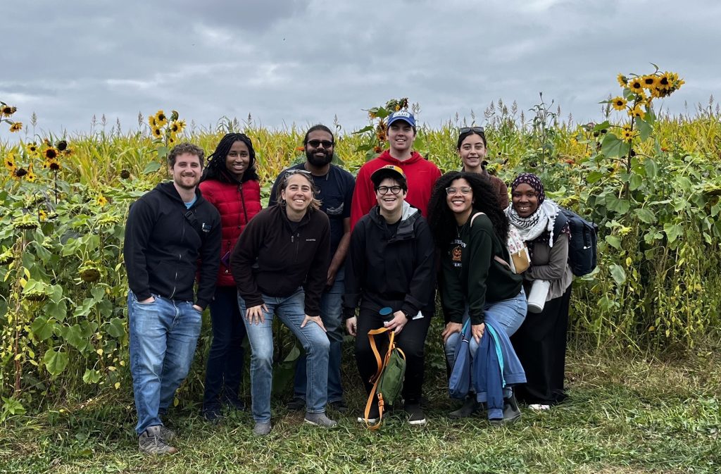 lab members in front of field of sunflowers an at apple and fruit farm